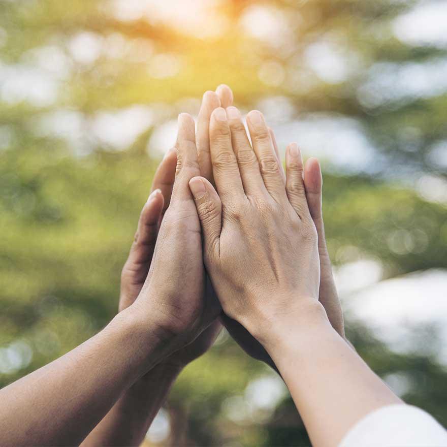 Hands of different ethnicities clap together